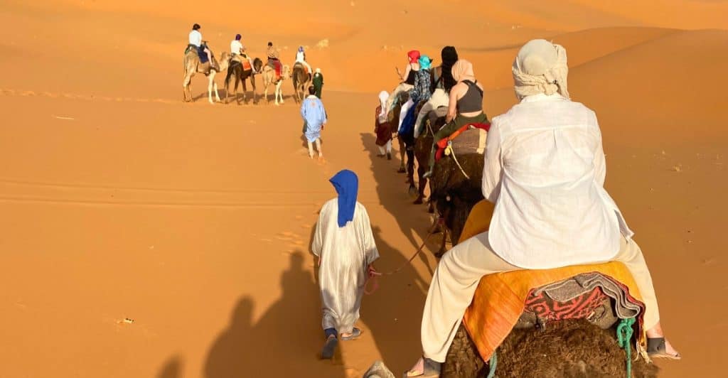 Photo of people riding camels in Morocco.