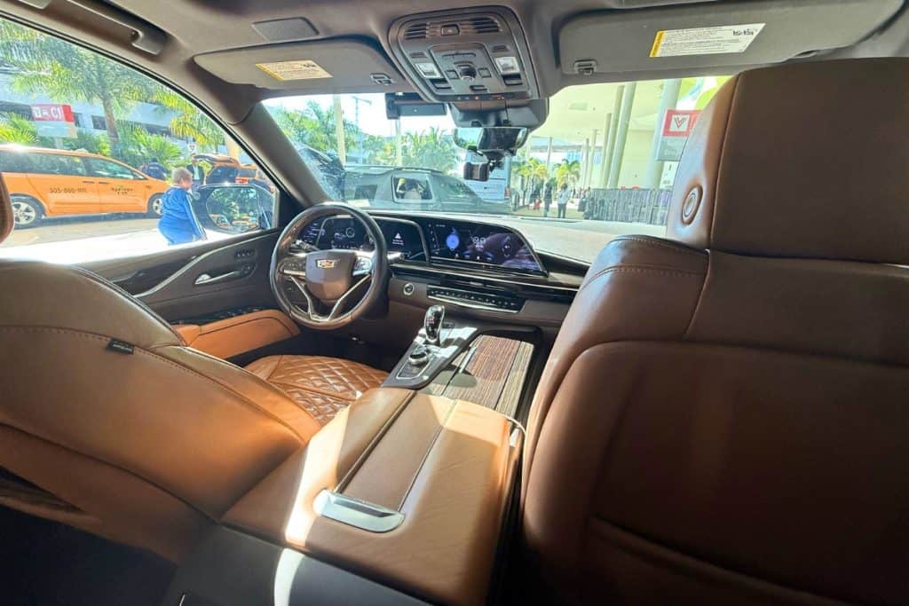Virgin Voyages MegaRockstar included car transfer. Luxury car interior with quilted brown leather seats and a Cadillac steering wheel during a private transfer.